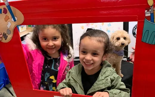 a couple of girls and a dog in a play structure
