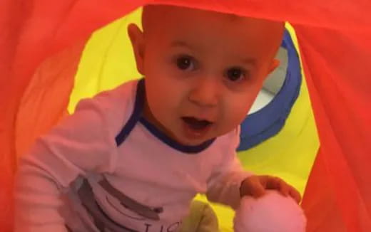 a baby in a red and yellow tent