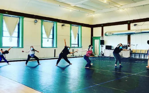 a group of people dancing in a room with green walls