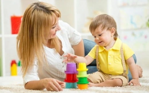 a person and a baby playing with toys