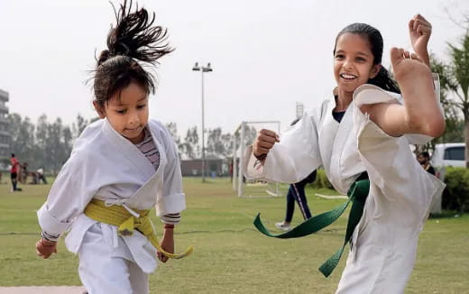 a person and a child running on a grass field