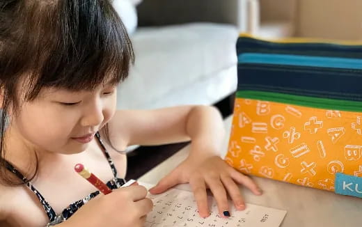 a young girl writing on a book