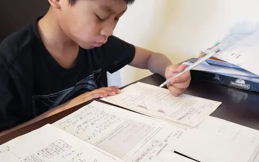 a boy writing on a piece of paper