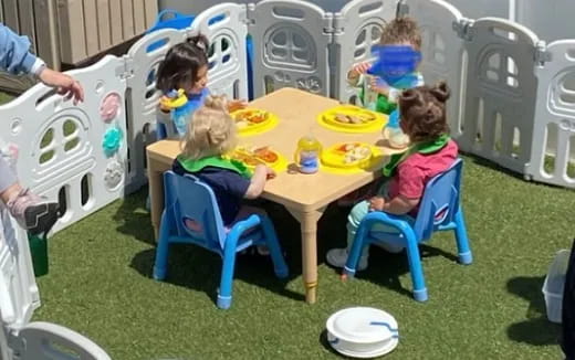 a group of children sitting at a table eating