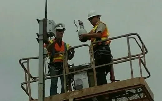 a few men wearing hardhats and reflectors on a boat