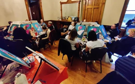 a group of people sitting in a room with laptops