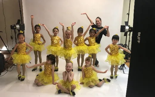 a group of children in yellow dresses
