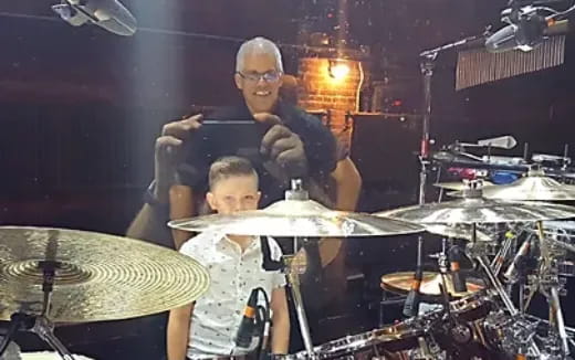 a person and a boy playing drums