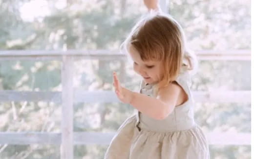 a little girl with her hands up