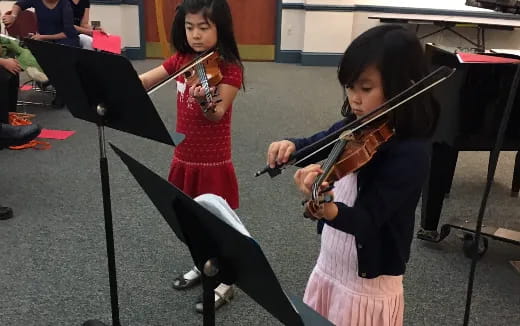 a couple of girls playing violin