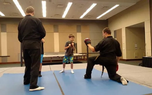 a person taking a picture of a boy in a boxing ring