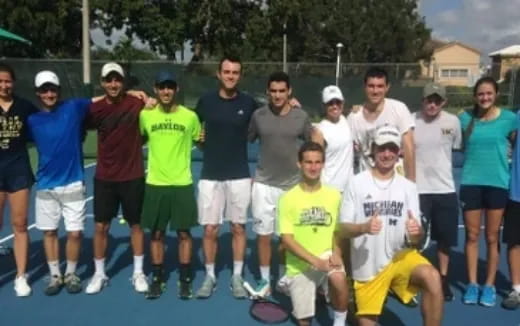 a group of people standing on a tennis court