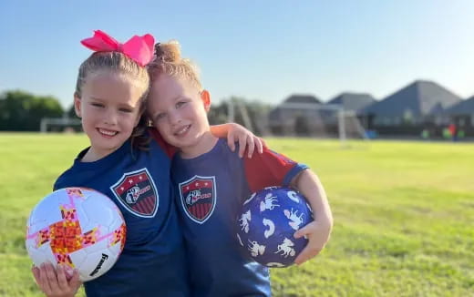 a couple of girls holding a ball