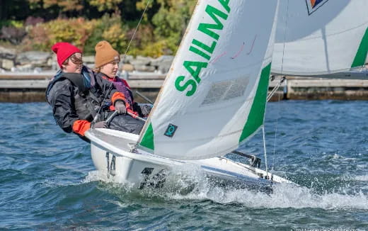 a couple of people on a sailboat on the water