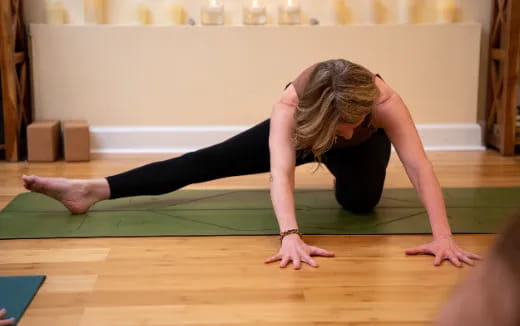 a woman doing yoga on a wooden floor