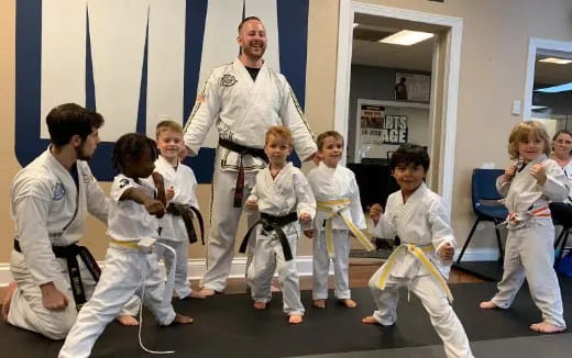 a person teaching children in karate uniforms