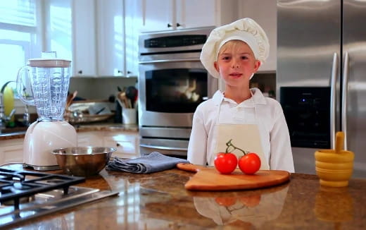 a boy in a chef's hat in a kitchen