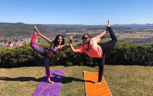 a man and woman doing yoga outside