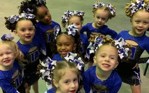 a group of children wearing blue and white dresses