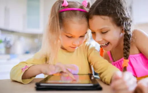 a couple of girls looking at a tablet