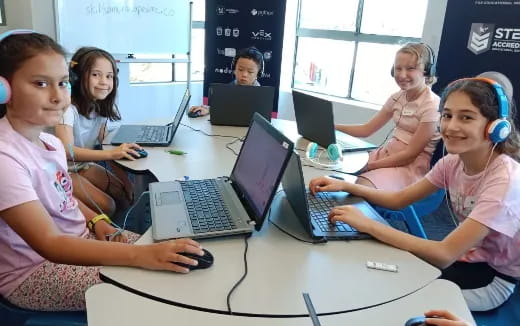 a group of children using laptops