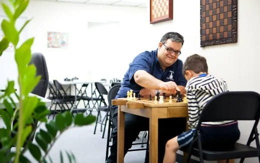 a person playing chess with another man