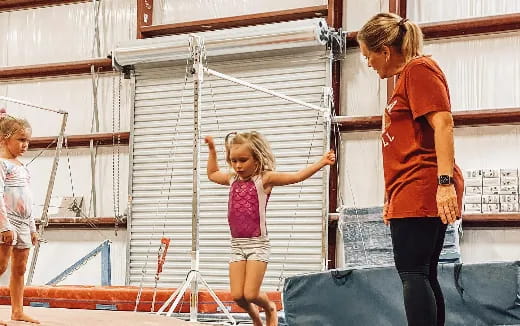 a person and a girl playing on a trampoline
