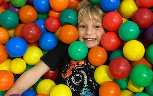 a boy in a ball pit