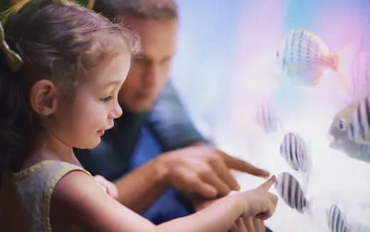 a woman and a child looking at a drawing