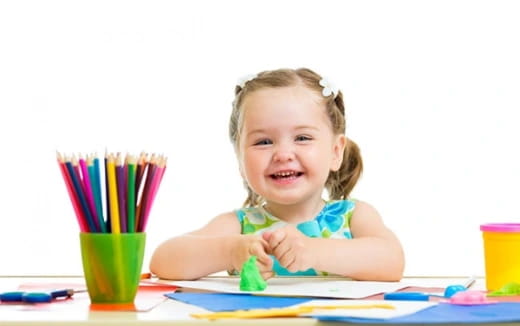 a girl coloring on a table