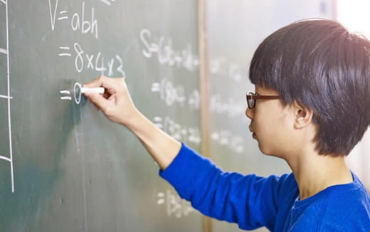 a person writing on a blackboard