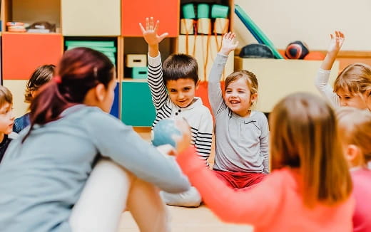 a group of children raising their hands