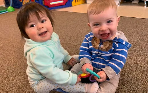 a couple of kids sit on the floor