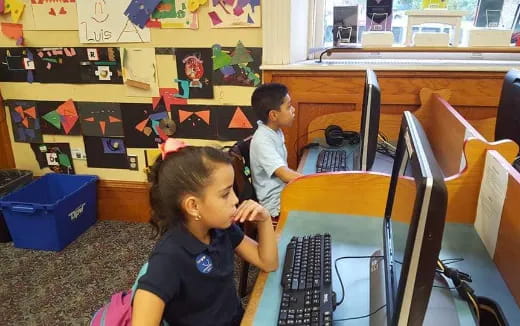a young girl sitting at a desk