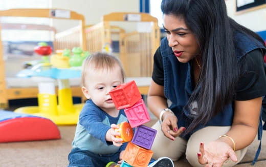 a person and a baby playing with toys