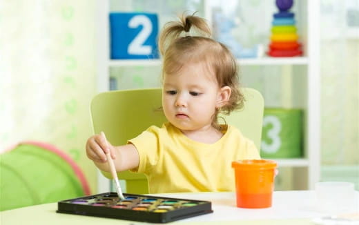 a little girl sitting at a table