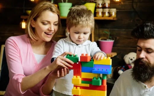 a man and woman with a child playing with toys