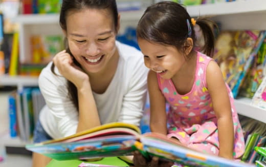 a person and a girl looking at a book