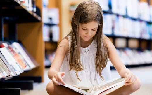 a young girl reading a book