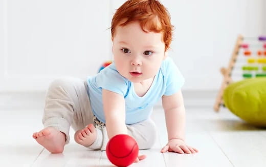 a baby playing with a ball
