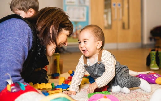 a person and a baby playing with toys