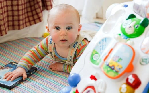 a baby playing with a remote control