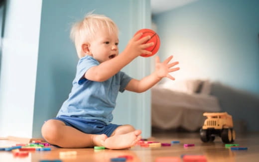 a baby playing with a ball
