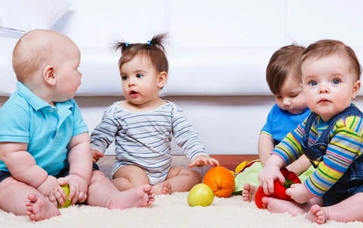 a group of babies sitting on the floor