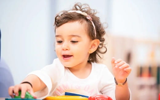 a little girl with her hands on her head