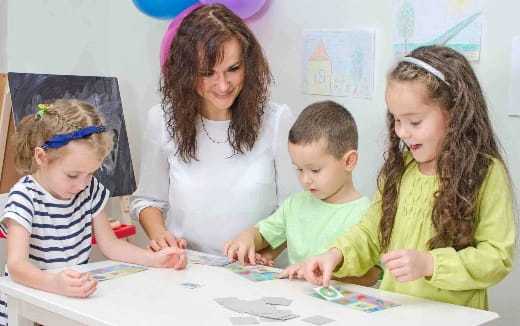 a person and children looking at a paper