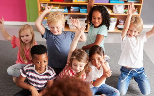 a group of children raising their hands