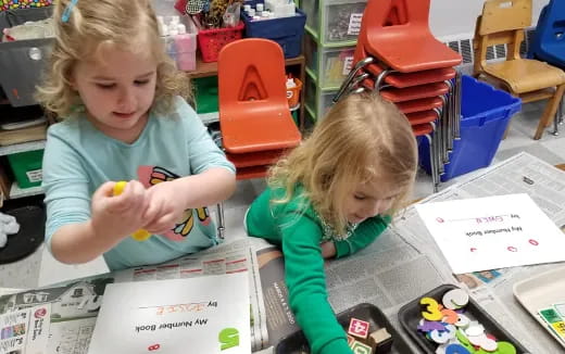 a couple of young girls looking at a book