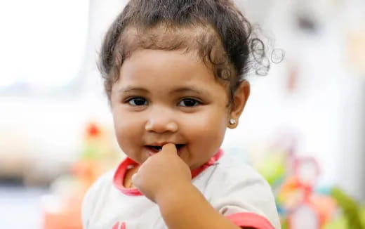 a baby with her hand on her chin