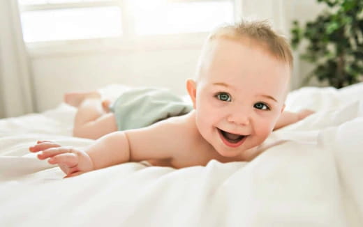a baby lying on a bed